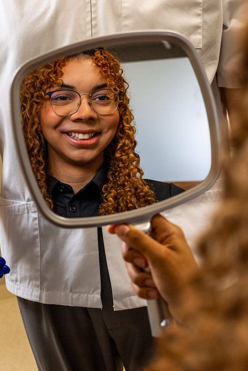 Apex-Dentures-Restoring-Smiles woman smiling in mirror